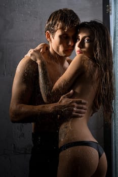 Shirtless man and girl topless embracing in shower view