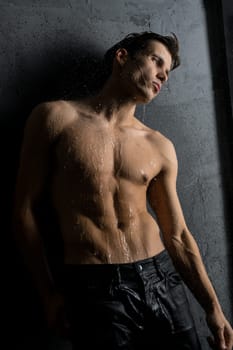 Shirtless muscular man wearing only jeans cropped view in shower