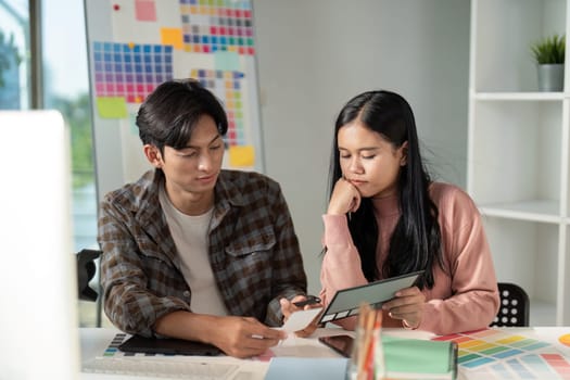 A team collaborates on design projects in a vibrant workspace showcasing creativity and teamwork in graphic development.