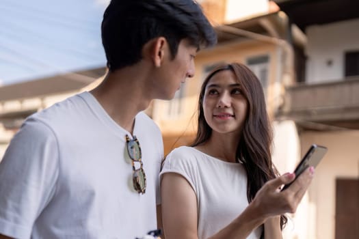 A couple enjoys their travel experience capturing joyful moments in a lively urban setting.
