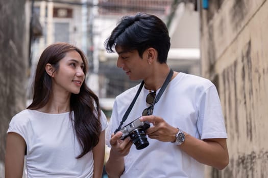 A couple explores a bustling alley capturing memories through in an urban travel adventure.