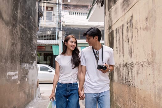 A couple strolls hand-in-hand through an urban alley capturing travel moments filled with joy and connection.