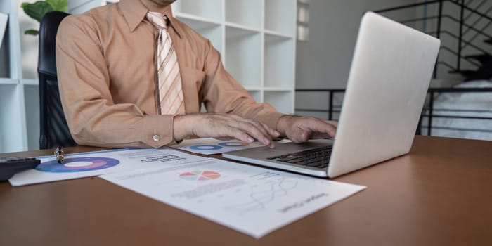 A business professional reviews data reports in a modern office focusing on strategic insights for better decision making.