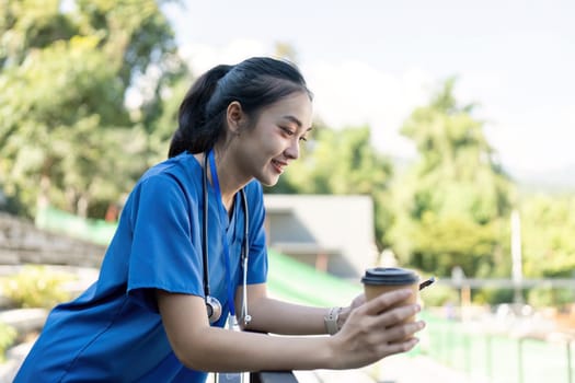 A nurse takes a moment to relax with coffee balancing work and wellbeing in a serene outdoor environment.