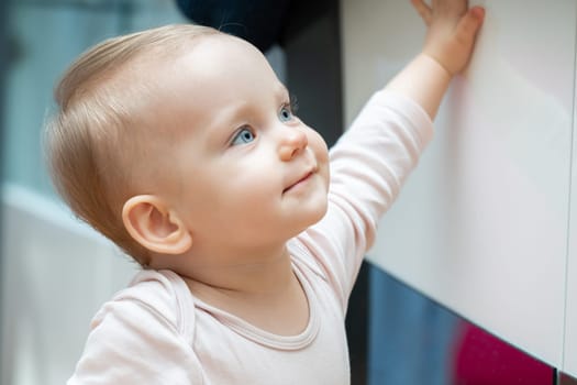Joyful baby reaching upward with a curious expression