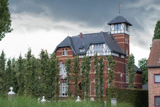 Detached three-storey villa in eclectic style with cottage style elements, built around 1910,against stormy sky and green trees,Belgian cultural heritage,Architecture,Belgium,Bree,September 18, 2023,