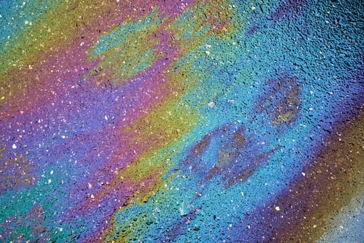 Colorful petroleum spill on asphalt, forming an artistic backdrop