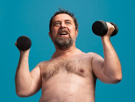 An elderly man is exercising with dumbbells in a vibrant indoor space. He is focused and determined as he lifts the weights, showcasing his commitment to maintaining a healthy lifestyle.