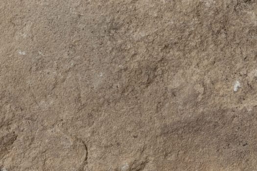 A rugged stone surface with earthy brown tones and natural textural details, ideal for use in organic or rustic-themed designs.