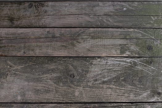 A wooden surface with horizontal alignment and visible grain patterns, showcasing a natural rustic aesthetic with a focus on texture and material.