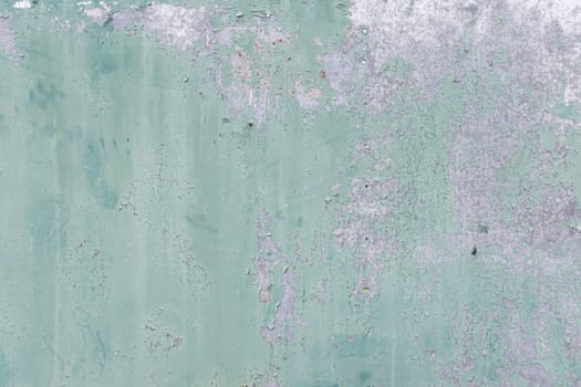A light green wall with weathered paint and subtle textures, showcasing peeling areas and an aged aesthetic with a focus on detail.