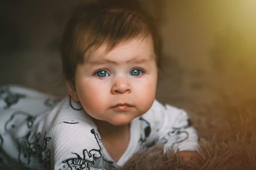 Cute baby girl close up crawling on bed. Adorable kid portrait. 5 month old child. Childhood and baby concept. High quality photo