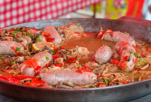 Big pan of andouillettte dish with the vegetables on a french market