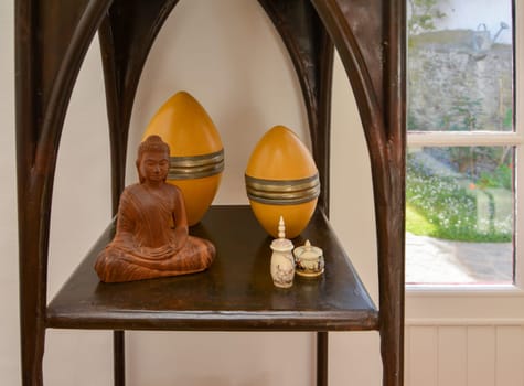 Wooden buddha statue on a shelf with the eggs
