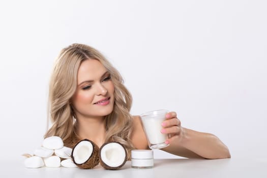 A woman joyfully explores luxurious coconut skincare products that highlight natural beauty and elegance