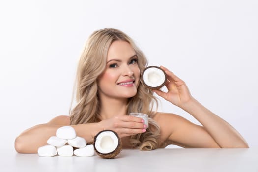 An incredibly beautiful woman is showcasing various coconut skincare products designed for achieving a natural glow