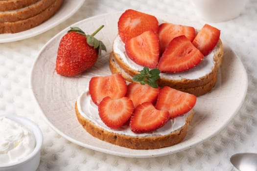 Homemade Crispbread toast with Cottage Cheese and Strawberry on white table.