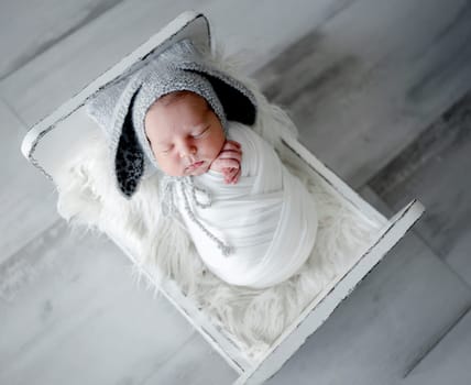 Newborn Baby Sleeps In Crib During Photo Session