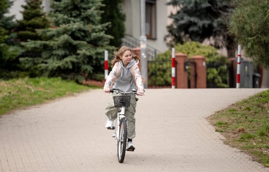 Girl Rides Bicycle On Pedestrian Road In Warm Spring Weather