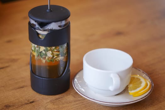 Enjoy herbal tea brewed in a French press, with fresh lemon slices for extra flavor