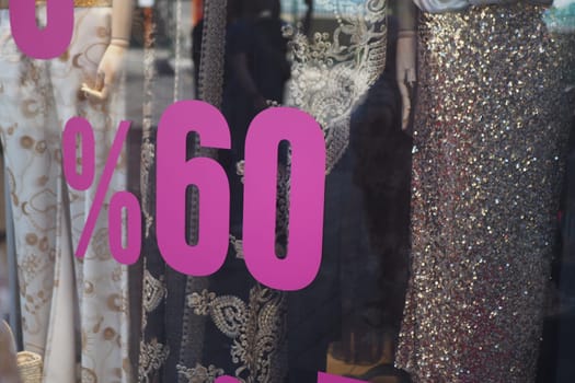 An eyecatching sale sign displaying an impressive 60 off is in a trendy boutiques window display