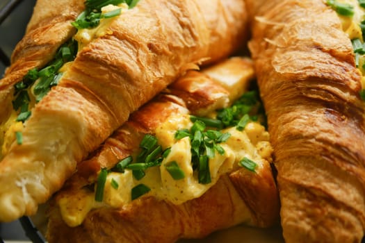 Enjoy these tasty croissant sandwiches filled with fluffy scrambled eggs and fresh herbs