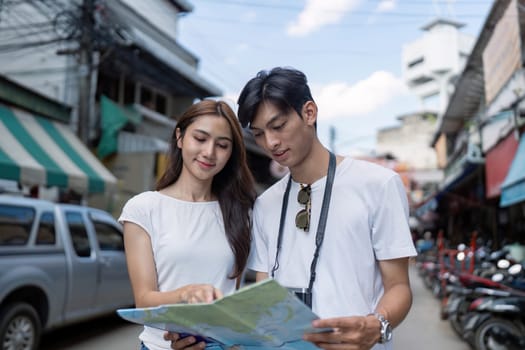 A couple navigates a vibrant street market local culture while planning their next travel adventure.