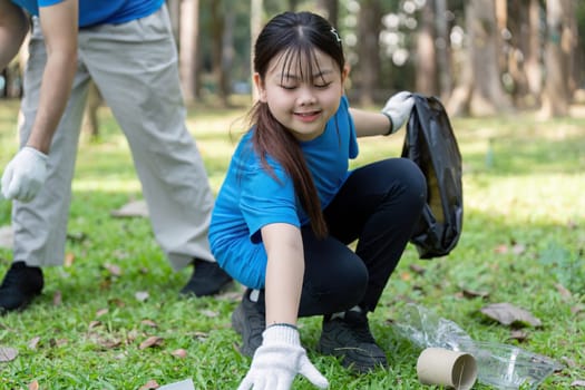 A family engages in clean up efforts collecting garbage in a park to promote environmental awareness and community involvement.