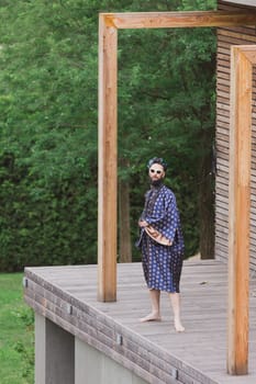 Young man wearing bathrobe night suit posing outdoor.