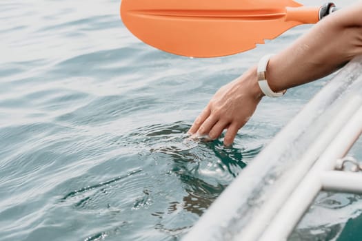 Woman in kayak back view. Happy young woman with long hair floating in transparent kayak on the crystal clear sea. Summer holiday vacation and cheerful female people having fun on the boat.