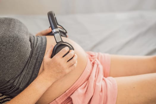 Melodies in the womb: Headphones placed on a pregnant belly, bonding through music, a heartwarming connection between mother and baby.