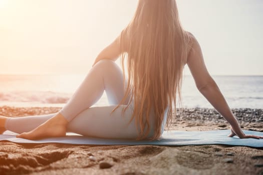 Middle aged well looking woman with black hair doing Pilates with the ring on the yoga mat near the sea on the pebble beach. Female fitness yoga concept. Healthy lifestyle, harmony and meditation.