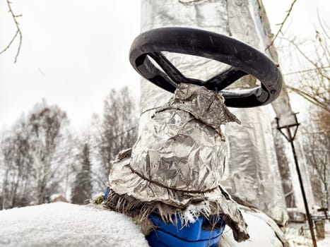 Heat pipes wrapped in silver insulation are visible in a snowy outdoor setting, indicating preparation for cold conditions.