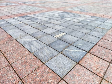 The pavement features a unique arrangement of stones with varying colors and patterns, set in a spacious outdoor area.
