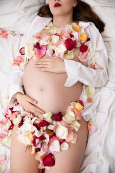 A stunning and beautiful maternity photoshoot showcasing a pregnant woman decorated with vibrant flower petals