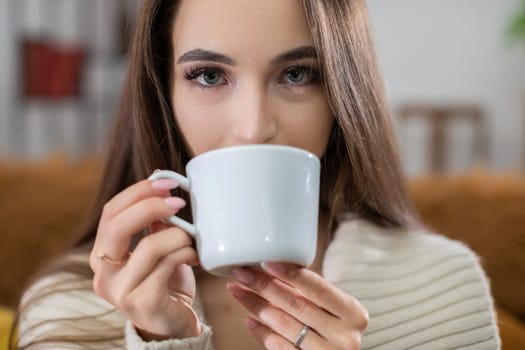 A woman leisurely sipping her coffee, capturing a warm and inviting moment filled with relaxation and comfort