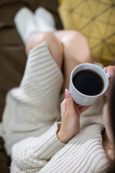 A serene and peaceful moment captured beautifully with a warm cup of coffee and cozy knitwear while at home