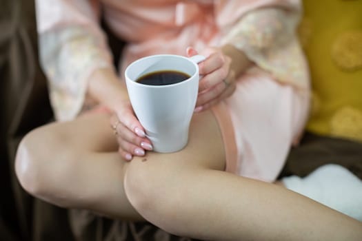 Enjoying a relaxing morning moment while sipping on coffee, dressed in soft attire, surrounded by a cozy atmosphere