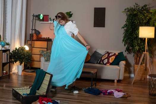 A vibrant scene of a woman joyfully trying on outfits in a cozy living room, full of creativity and comfort