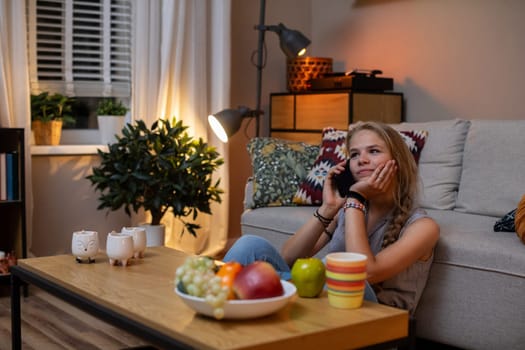 A cozy and inviting evening scene showcasing a woman engaged in a phone call surrounded by an array of fruits