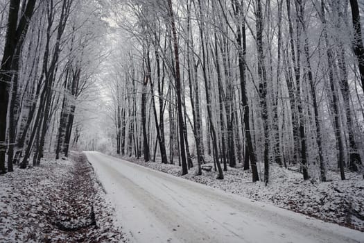 Snowy winter road with car. Dangerous car driving in the mountains in the winter. Concept for transportation, cars and travel.