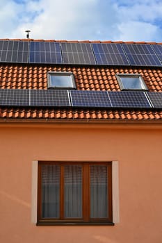 Family house with solar panels on the roof. Home photovoltaic power plant. Concept for industry and green cheaper electricity from renewable sources.