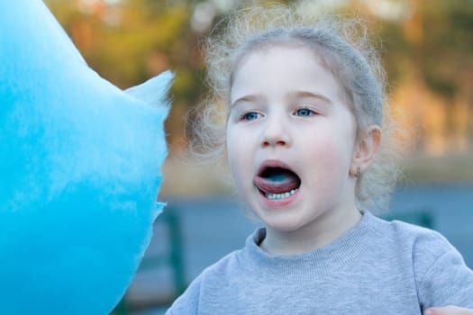 little pretty girl eating cotton candy , people