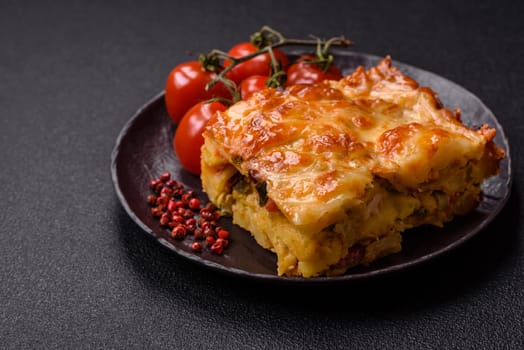 Lasagna or pasta layered with meat, cheese, salt, spices and herbs on dark concrete background