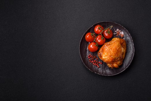 Delicious juicy chicken thighs baked with salt, spices and herbs in a ceramic plate on a dark concrete background