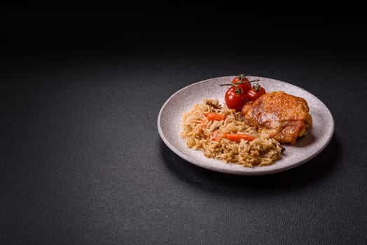 Delicious fresh pilaf with rice, carrots, meat, onions, spices and berries on a ceramic plate on a dark concrete background