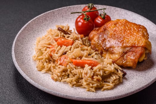Delicious fresh pilaf with rice, carrots, meat, onions, spices and berries on a ceramic plate on a dark concrete background