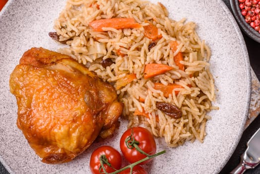 Delicious fresh pilaf with rice, carrots, meat, onions, spices and berries on a ceramic plate on a dark concrete background
