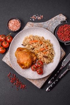 Delicious fresh pilaf with rice, carrots, meat, onions, spices and berries on a ceramic plate on a dark concrete background