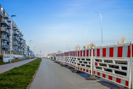 The roads of the city under construction are surrounded by barrier fences with red stripes. High quality photo
